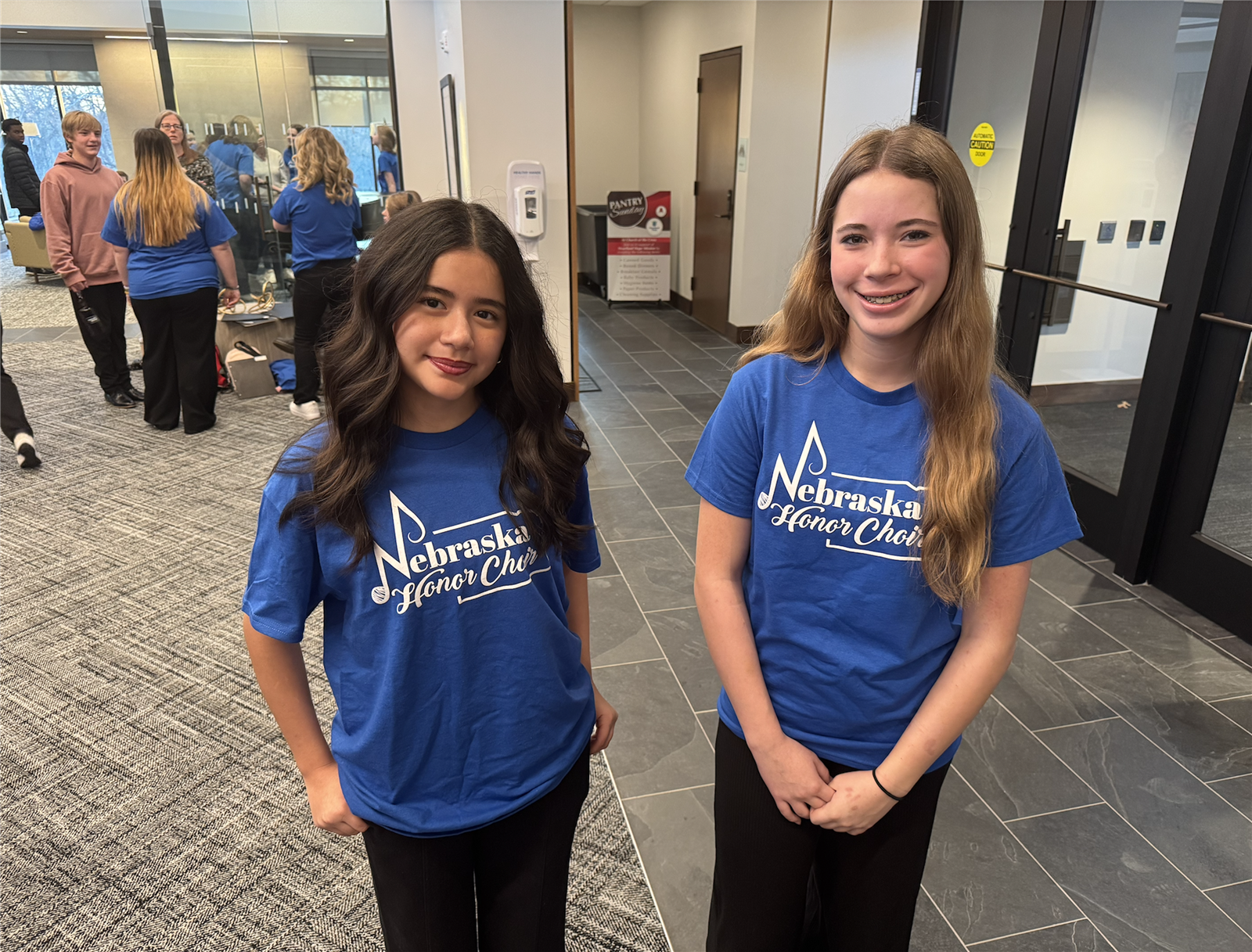  Two students pose for a picture wearing matching Nebraska Honor Choir t-shirts